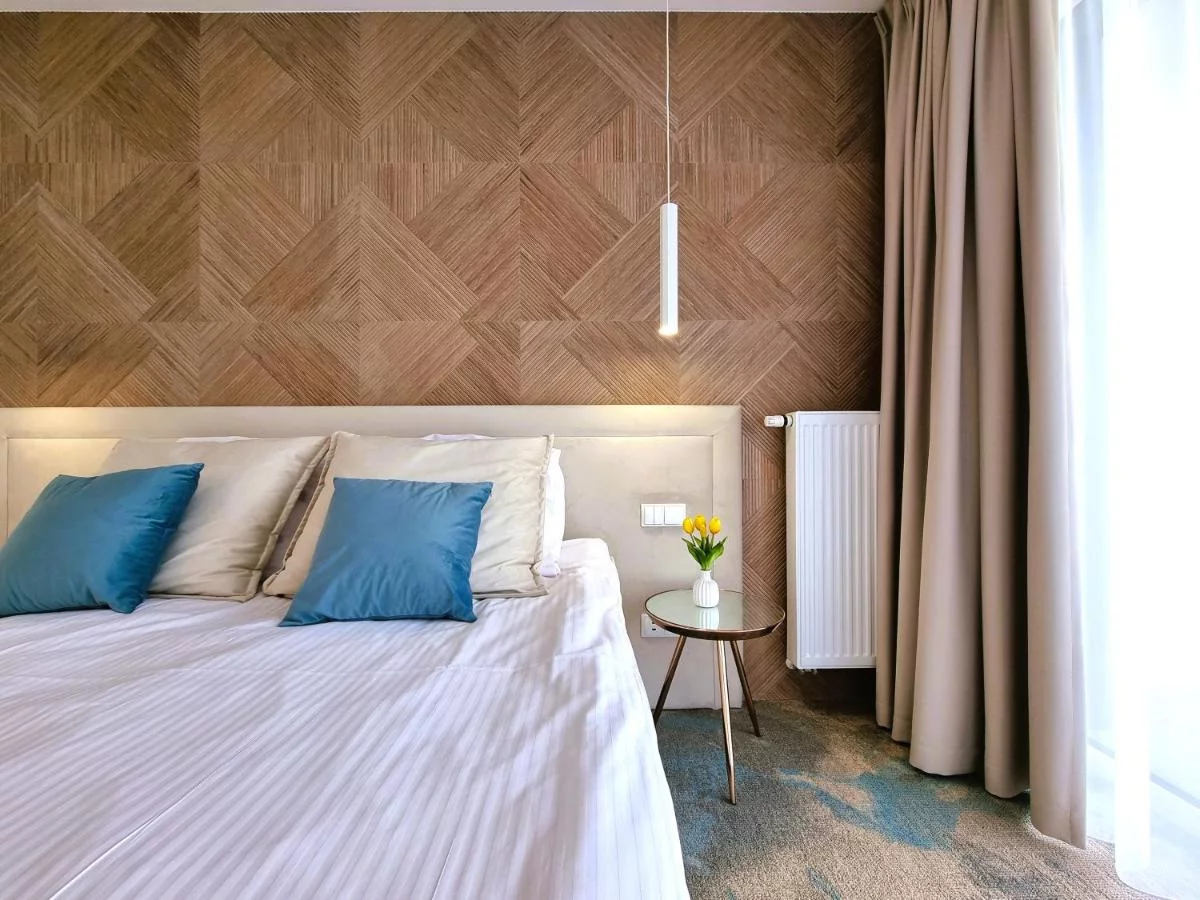 Zimmer mit flachem hellem Kopfteil vor Holzpaneelwand