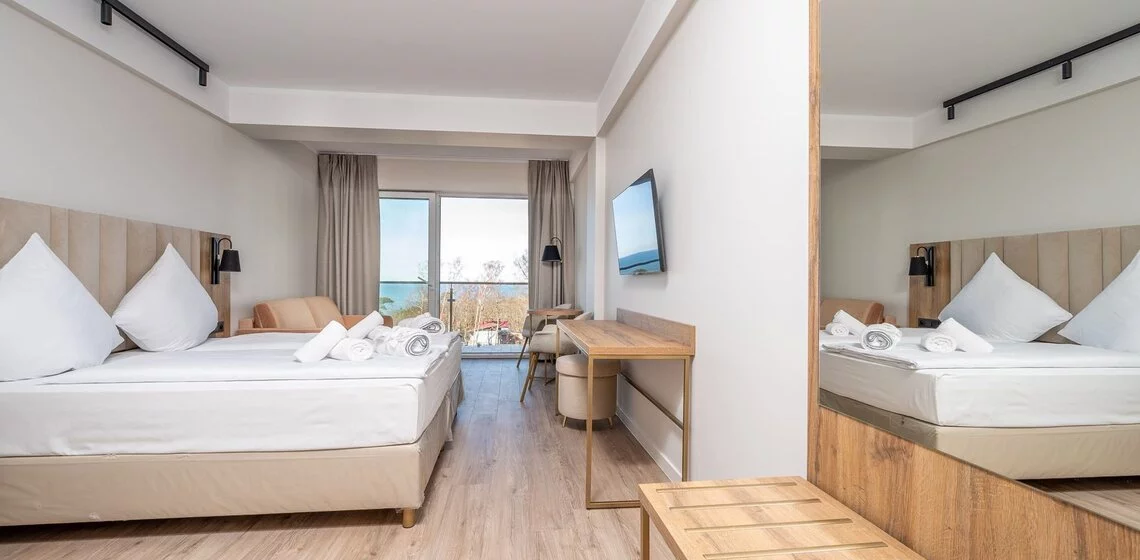 Helles Hotelzimmer am Meer mit beigem Kopfteil und Bettbox